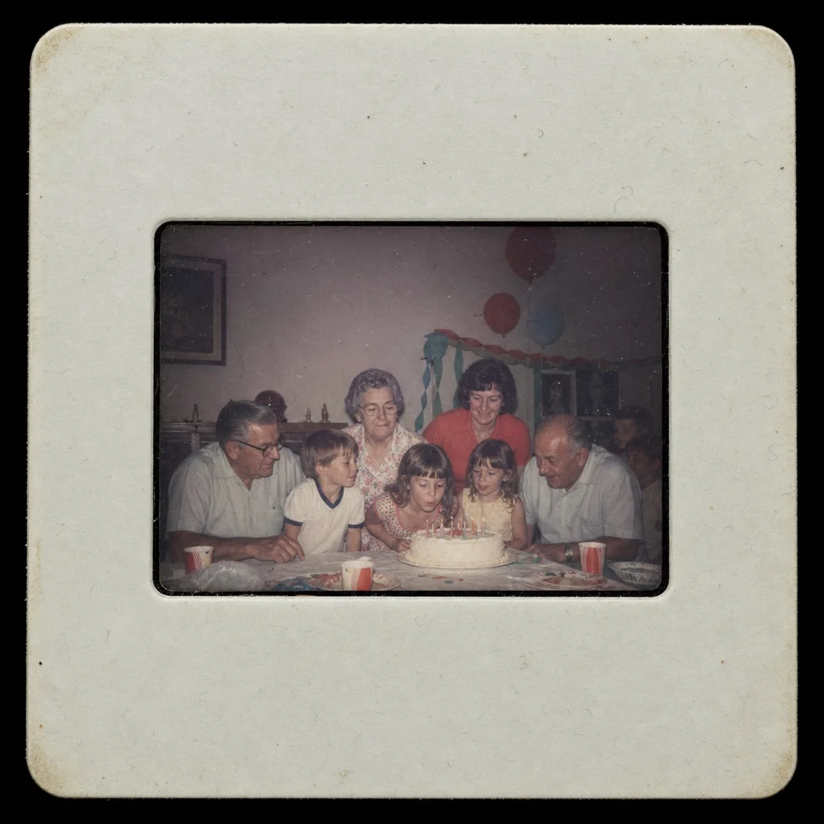 Mounted 35mm slide showing a faded child birthday party in a living room.