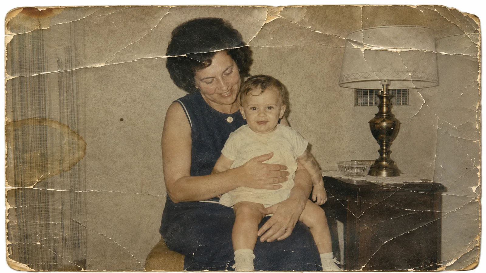 Cracked family room portrait before restoration with faded color and worn paper edges.