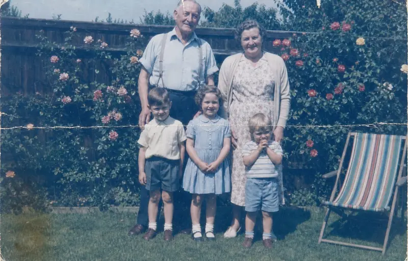Faded family portrait before restoration with creases and worn color.